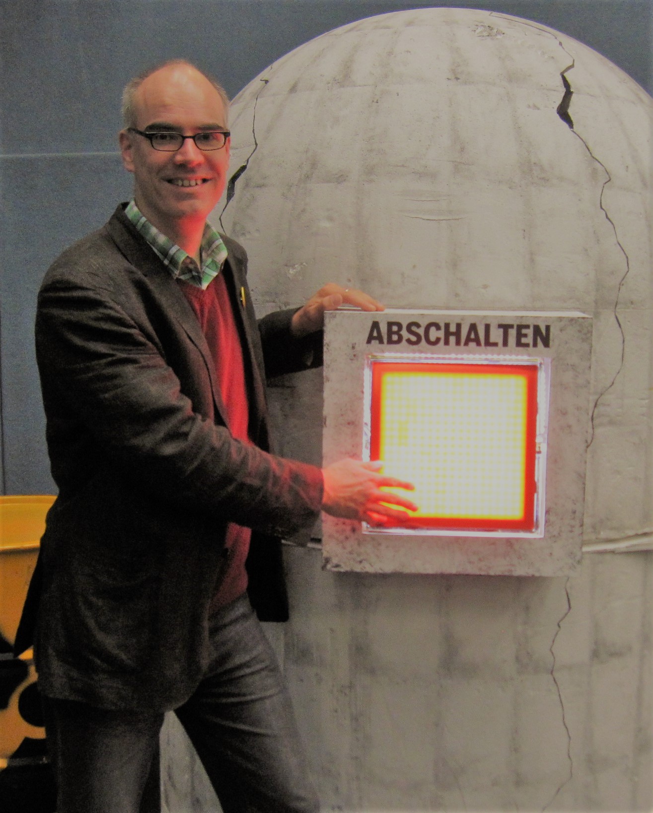 Modell eines schadhaften Atomreaktors, Burkhard Pohl betätigt symbolisch den daran angebrachten Ausschalter.